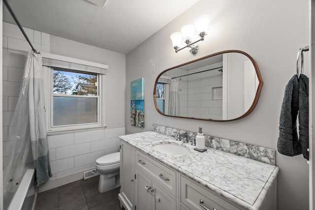 bathroom featuring tile patterned flooring, toilet, visible vents, vanity, and tile walls