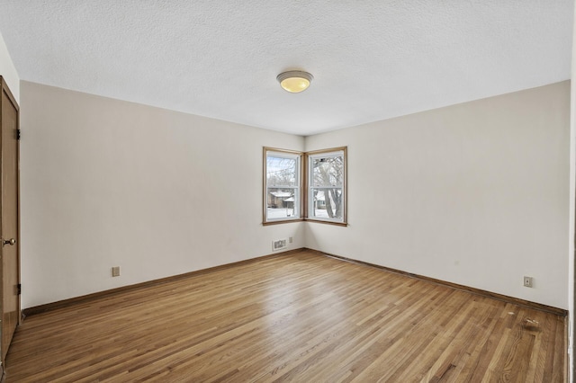 empty room featuring light hardwood / wood-style floors and a textured ceiling