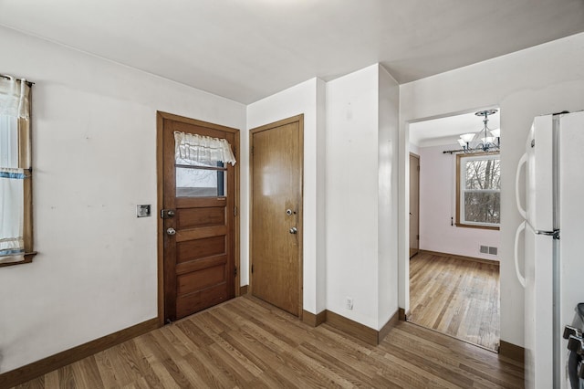 entryway featuring wood-type flooring and a chandelier