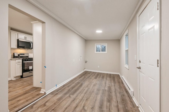 empty room featuring light hardwood / wood-style flooring and a baseboard radiator