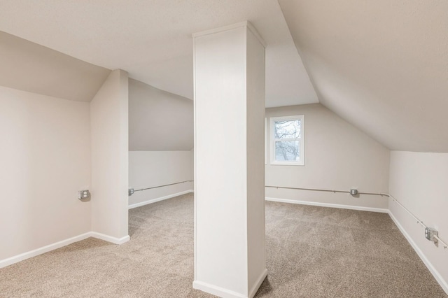 bonus room with light colored carpet and lofted ceiling