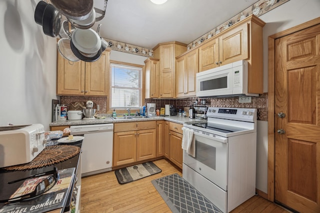 kitchen featuring white appliances, light brown cabinetry, light wood-type flooring, and sink