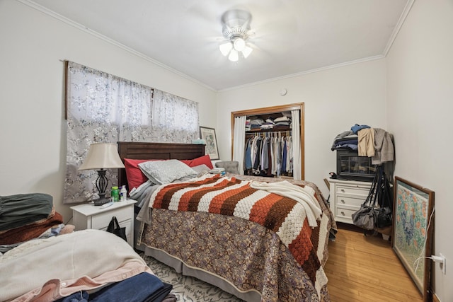 bedroom with a closet, light wood-type flooring, ceiling fan, and ornamental molding