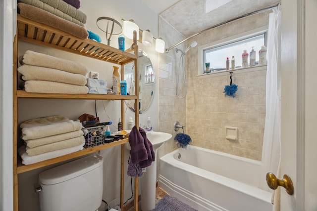 bathroom featuring shower / bath combo with shower curtain and toilet