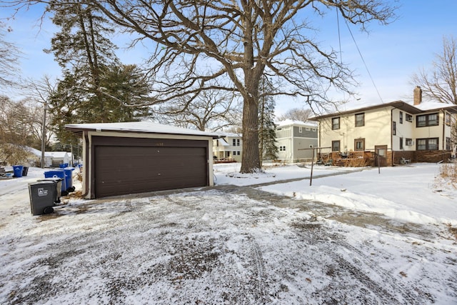 yard covered in snow with a garage and an outbuilding