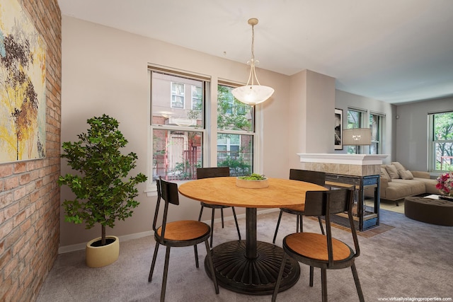 dining room featuring carpet flooring, plenty of natural light, and a multi sided fireplace