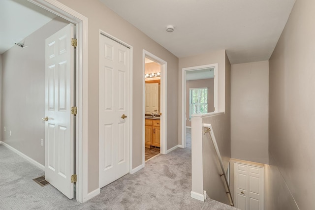 corridor featuring light colored carpet