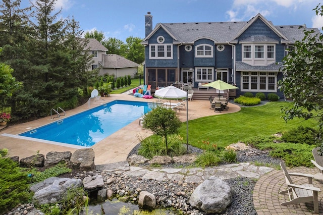 rear view of property featuring a patio area and a yard