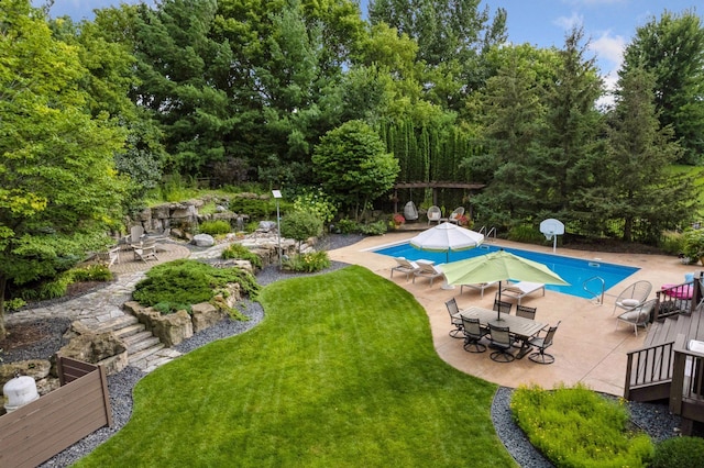 view of pool featuring a lawn and a patio