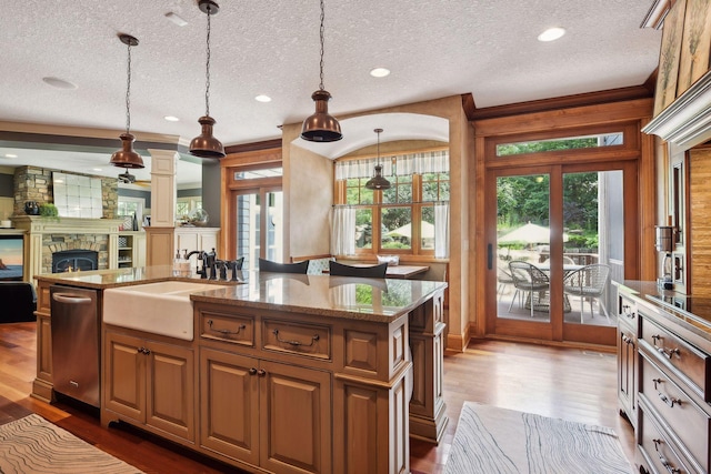 kitchen with french doors, a kitchen island with sink, pendant lighting, and sink