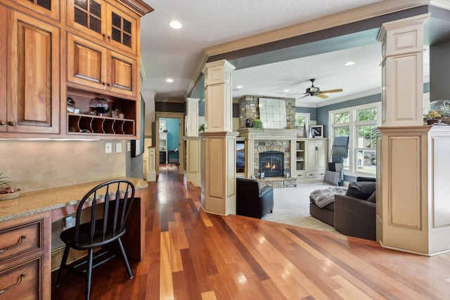 kitchen featuring hardwood / wood-style flooring, ceiling fan, ornate columns, and crown molding