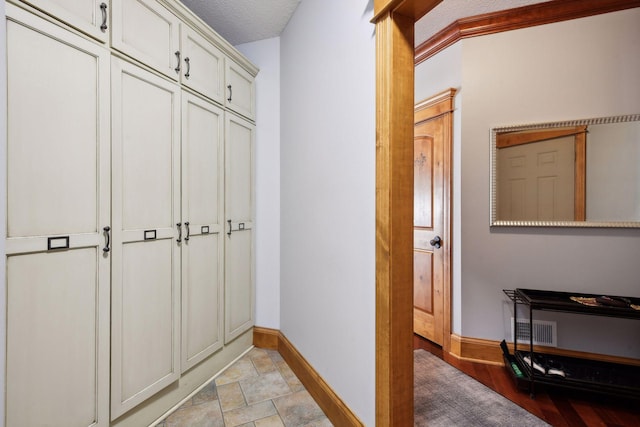 interior space with ornamental molding and a textured ceiling