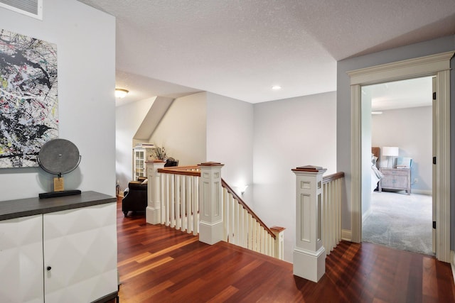 stairway with a textured ceiling and hardwood / wood-style flooring