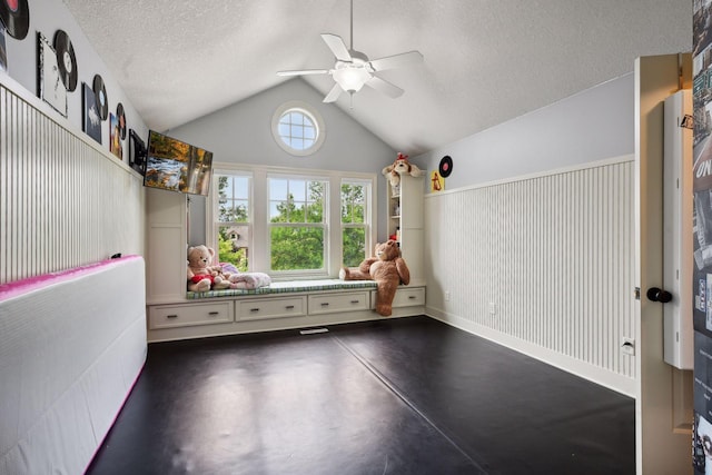 interior space featuring ceiling fan, a textured ceiling, and vaulted ceiling