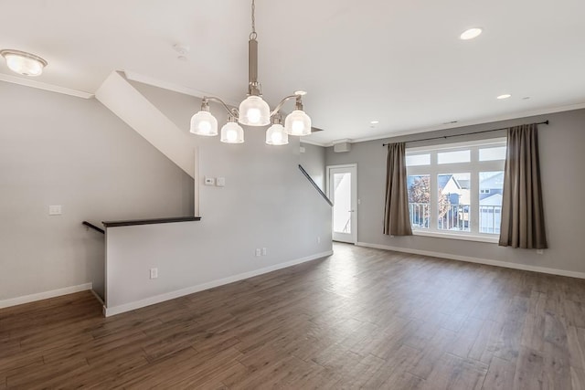 unfurnished living room with a chandelier, dark hardwood / wood-style flooring, and crown molding