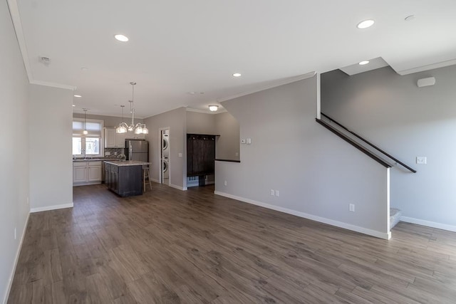 unfurnished living room featuring ornamental molding and dark wood-type flooring