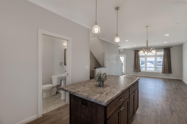 kitchen featuring dark brown cabinets, a center island, hardwood / wood-style floors, and a notable chandelier