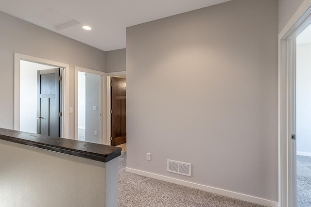 interior space with light carpet and kitchen peninsula