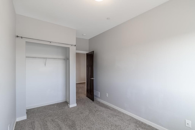 unfurnished bedroom featuring carpet floors and a closet