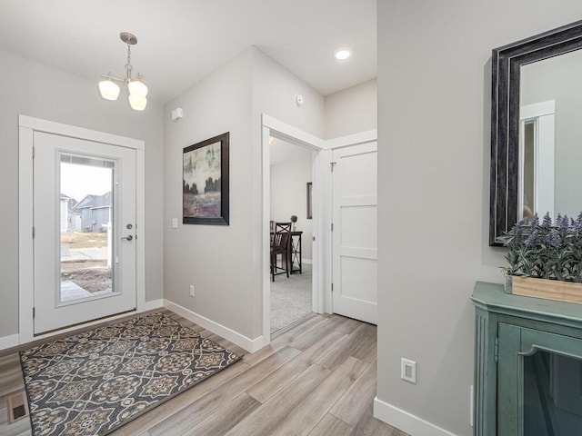 foyer featuring a chandelier and light wood-type flooring