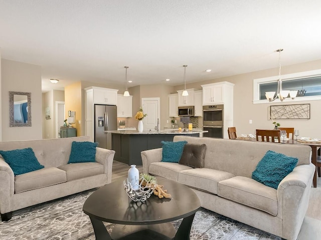 living room featuring a chandelier and sink