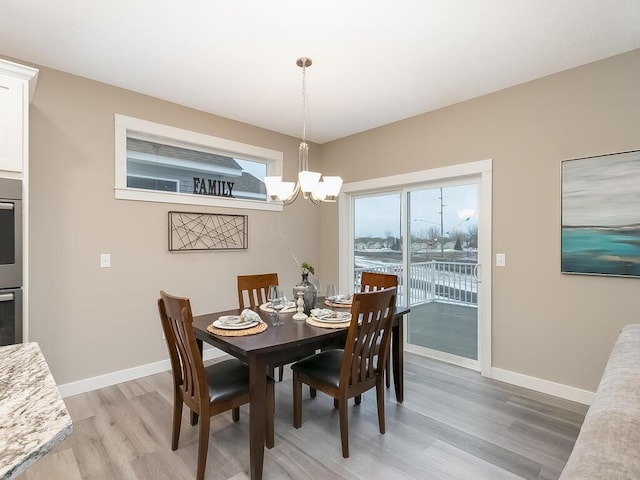 dining room with light hardwood / wood-style flooring and a notable chandelier