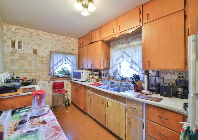 kitchen featuring white appliances, sink, and a wealth of natural light