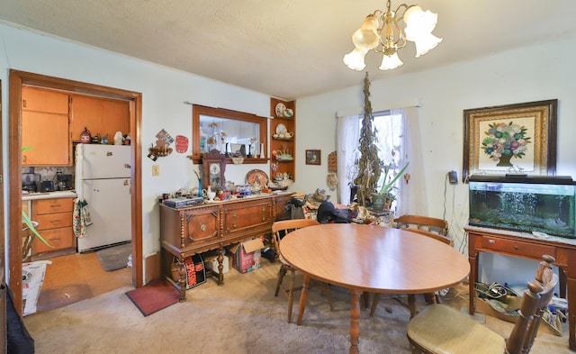 dining space featuring light colored carpet, a textured ceiling, and a chandelier