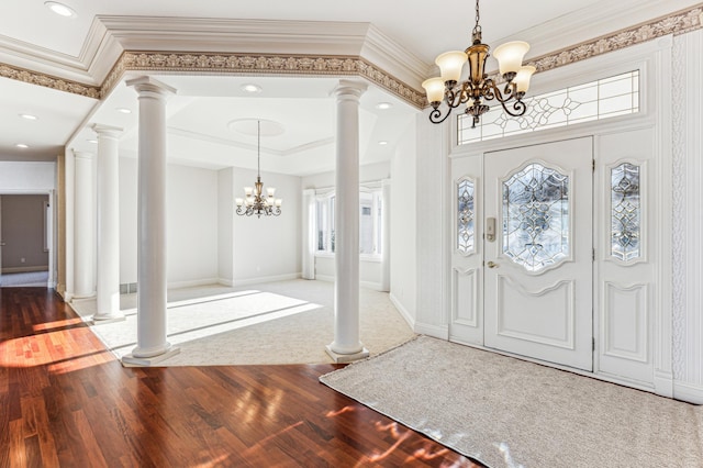 entrance foyer with an inviting chandelier, crown molding, decorative columns, and hardwood / wood-style floors