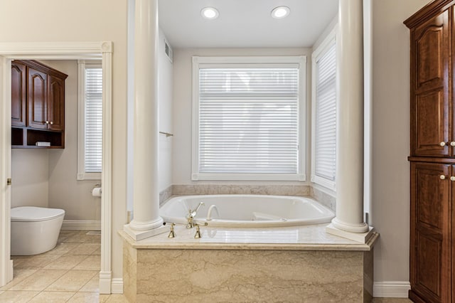 bathroom featuring a relaxing tiled tub, tile patterned floors, toilet, and ornate columns