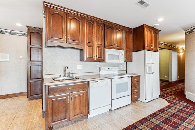 kitchen featuring white appliances, sink, and light tile patterned floors