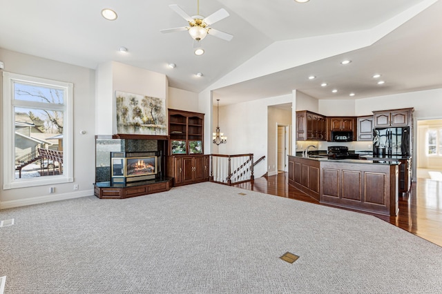 living area with vaulted ceiling, a multi sided fireplace, a wealth of natural light, and recessed lighting