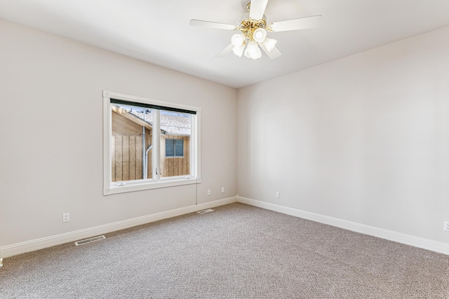 carpeted spare room with ceiling fan, visible vents, and baseboards