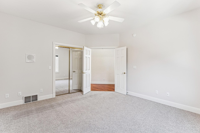 unfurnished bedroom featuring a closet, visible vents, a ceiling fan, carpet flooring, and baseboards