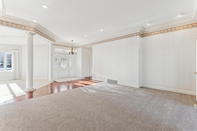 interior space featuring wallpapered walls, decorative columns, visible vents, and ornamental molding