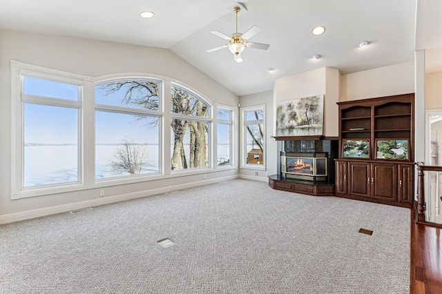 unfurnished living room with recessed lighting, a glass covered fireplace, ceiling fan, vaulted ceiling, and baseboards