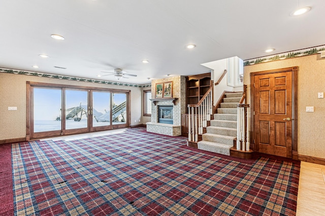 unfurnished living room featuring recessed lighting, a fireplace, a ceiling fan, baseboards, and stairway