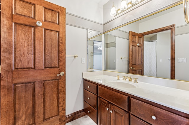 full bathroom featuring curtained shower, vanity, and baseboards