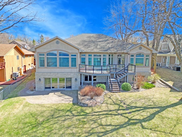 rear view of property featuring central AC unit, a deck, a yard, stucco siding, and stairs