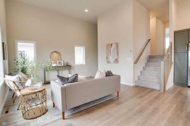 living room featuring light hardwood / wood-style flooring and a high ceiling