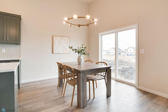 dining space with light wood-type flooring and an inviting chandelier