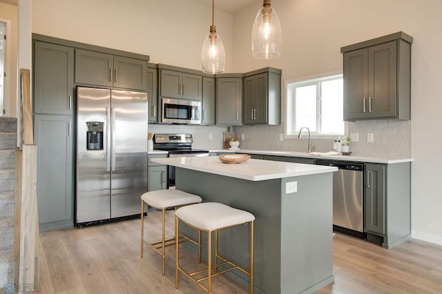 kitchen featuring light hardwood / wood-style flooring, a center island, stainless steel appliances, and tasteful backsplash