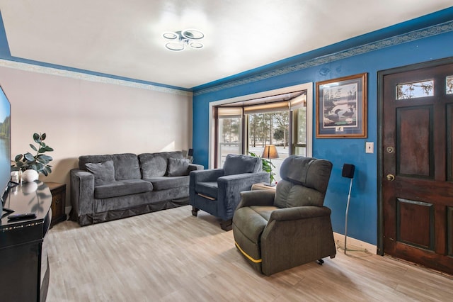 living room with ornamental molding and light wood-type flooring