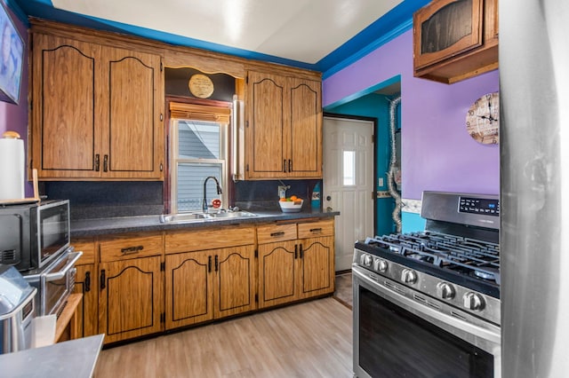 kitchen with sink, tasteful backsplash, light hardwood / wood-style flooring, and stainless steel appliances