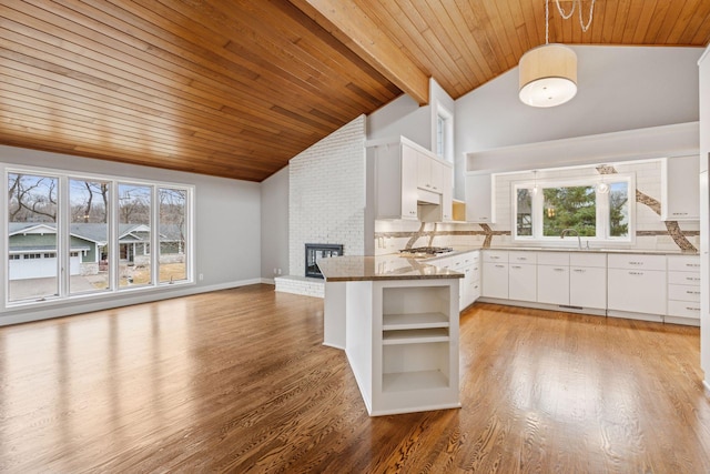 kitchen featuring decorative backsplash, open shelves, light wood-style floors, and a fireplace