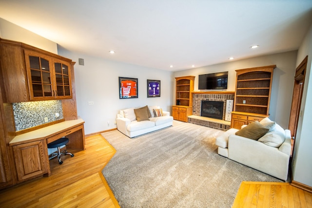 living room featuring a brick fireplace and light hardwood / wood-style flooring