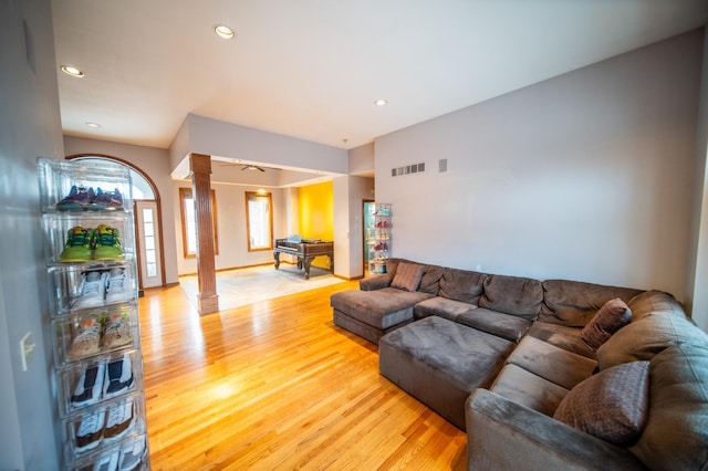 living room featuring decorative columns and light hardwood / wood-style flooring