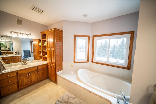 bathroom featuring vanity and tiled tub