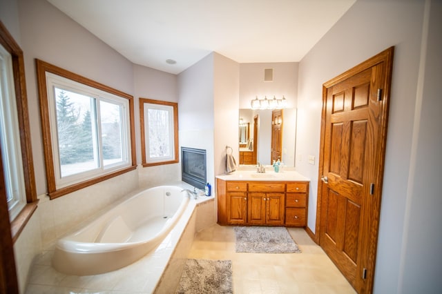 bathroom with vanity and tiled bath