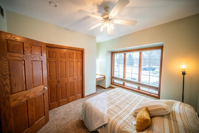 bedroom with ceiling fan, a closet, and light carpet